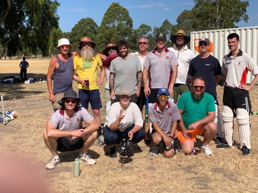 Team photo with dray grass, Kev looking professional, and shipping container in background