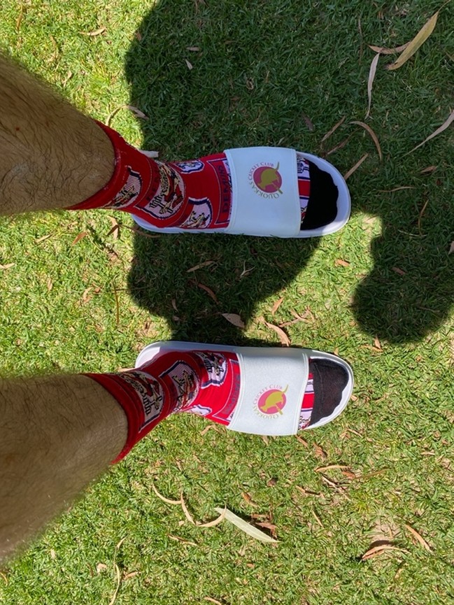 Dylan taking a picture of his Quokka tour slides, matched to festive socks