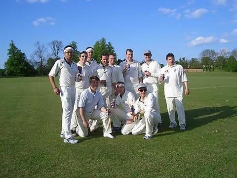 Young men in cricket whites holding cans of beer on a sunny summers day in the UK